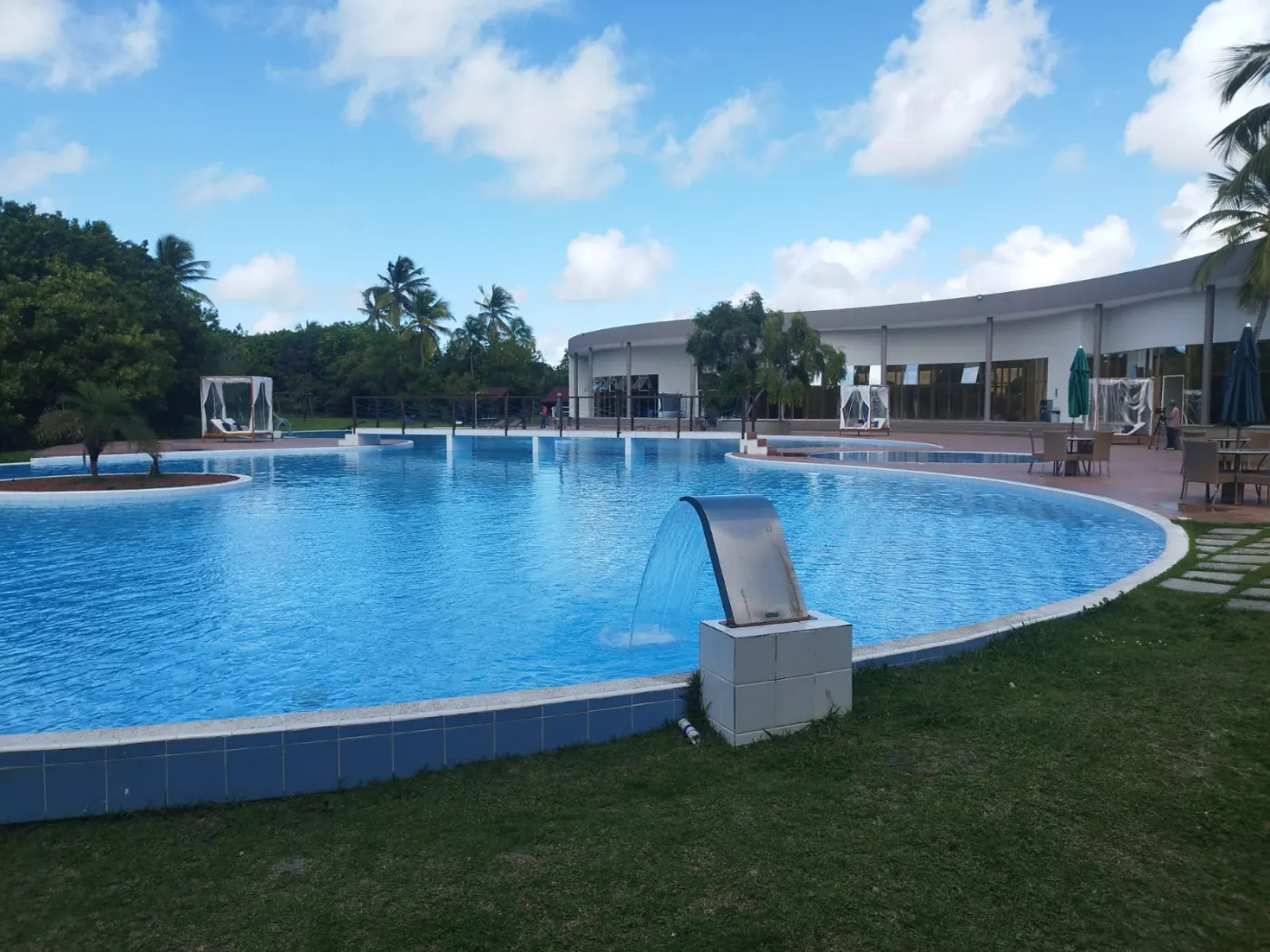 Piscina do Belleville em dia de sol, com o clube ao fundo