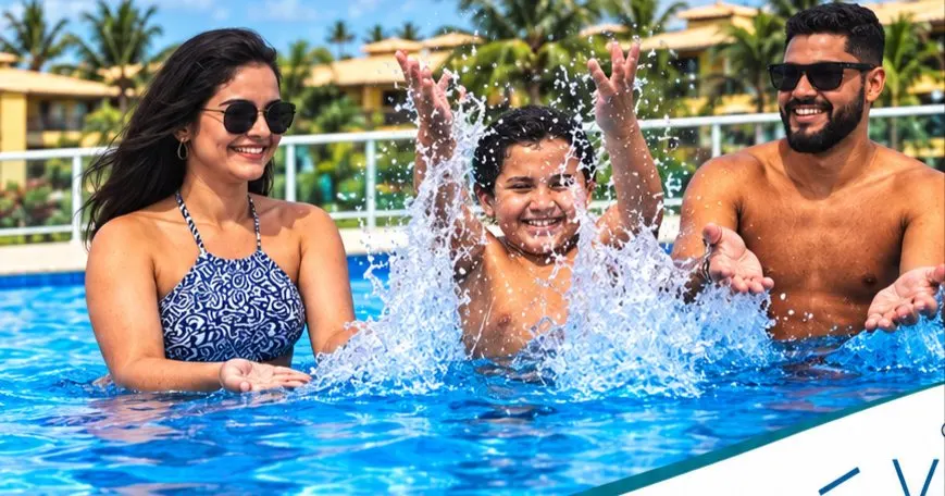 Família na piscina do Villa das Águas, com os blocos e os coqueiros ao fundo